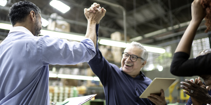 Coworkers celebrating some good news in a factory