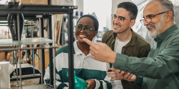 One senior man explaining students 3d printing