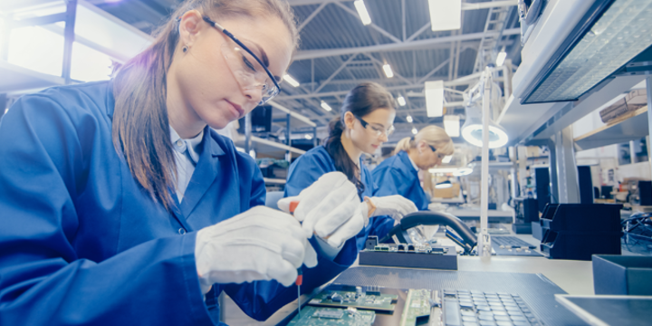 emale Electronics Factory Worker in Blue Work Coat and Protective Glasses