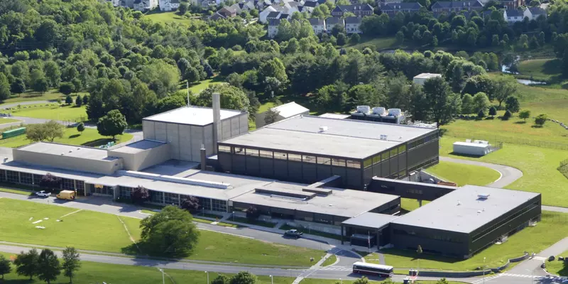 View from above shows NIST's Center for Neutron Research building with green lawns and trees.