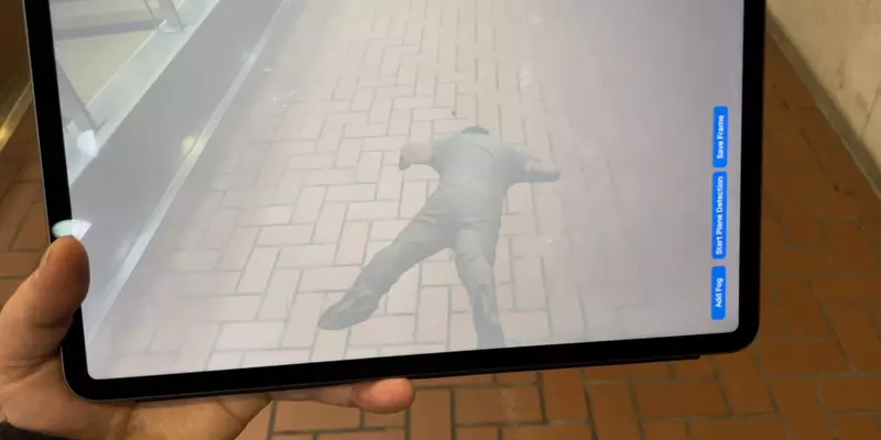 iPad using augmented reality overlay to show an injured person on the floor. 