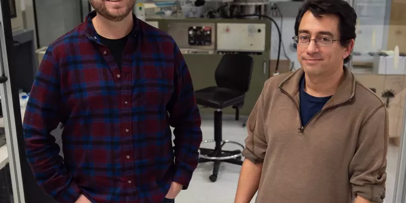 Sam Oberdick and Gary Zabow pose for a picture, standing together with lab equipment in the background.