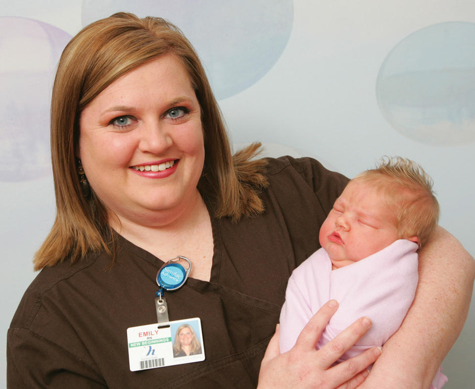 Heartland Health photo of nurse holding a newborn.