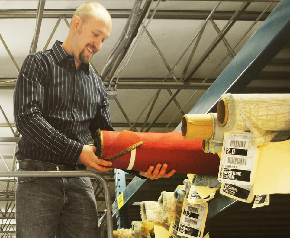 Photo of Momentum Group employee looking at fabric inventory.