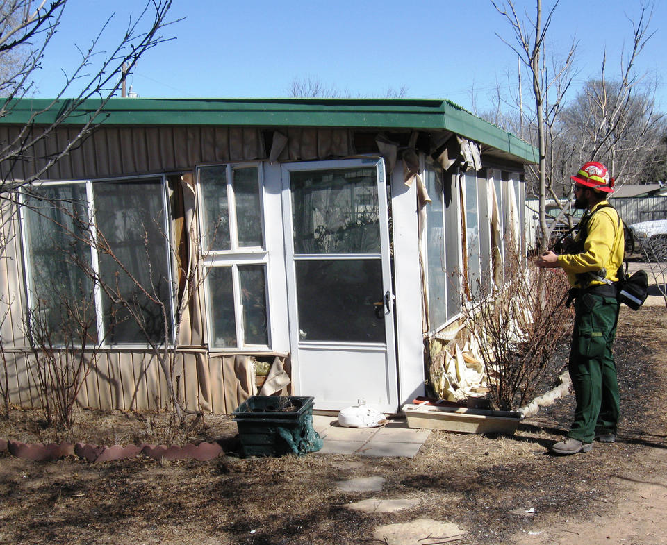 A member of a joint NIST-Texas Forest Service study team collects data on a Amarillo, Texas, building damaged by wildfires in February 2011.