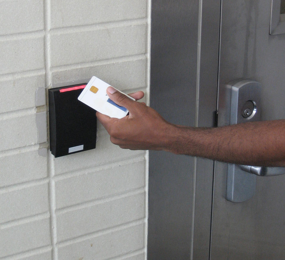 Photo of a person holding a PIV card up to a reader