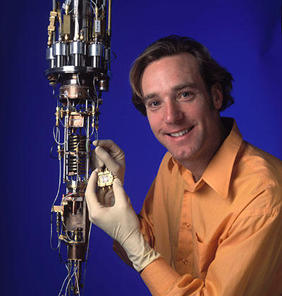 NIST physicist Ray Simmonds holds a protective box containing "artificial atoms" that might be used in quantum computers.