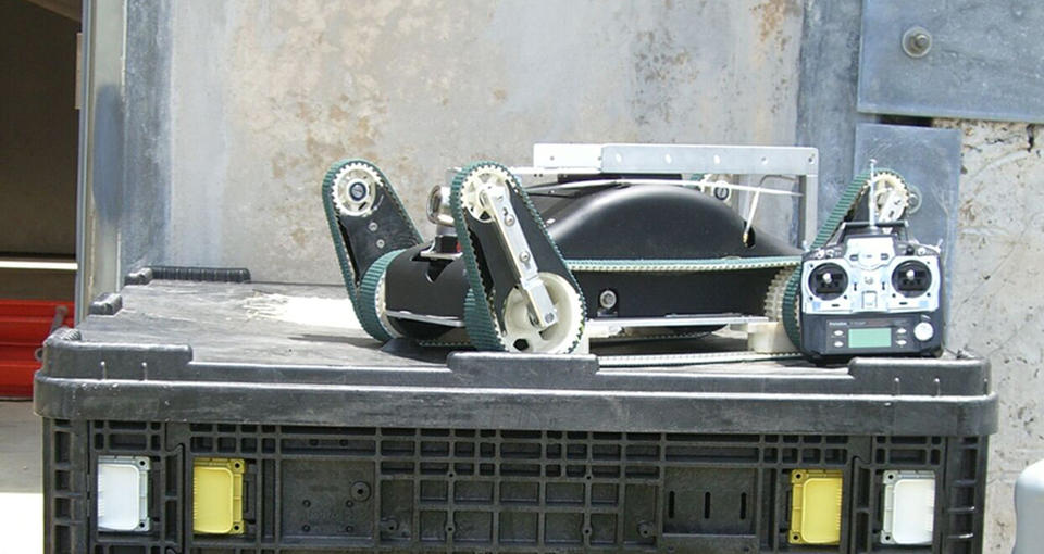 Photo of an urban search and rescue robot and its control unit sit atop a packing crate