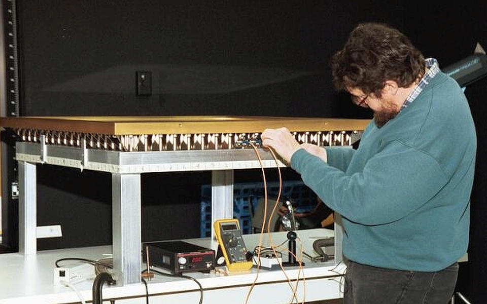 A side view of the DOI encasements with a NIST engineer working on them.