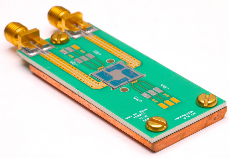 Quantum Voltage Noise Source a rectangular block of wood covered in green with markings, 2 bolts and 2 screws