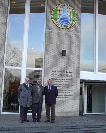 Three NIST scientists standing in front of the OCPW building