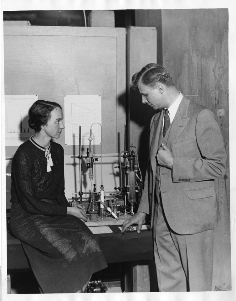 physicist Marion Langhorne Howard Brickwedde (left) and Dr. Ferdinand Brickwedde (right) with the apparatus for making heavy water between them