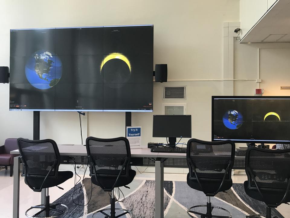 Picture of a large data visualization screen and a smaller screen that controls it