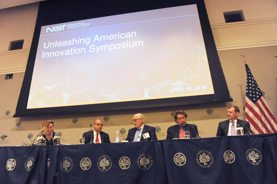 Five people sitting at a table for a panel discussion