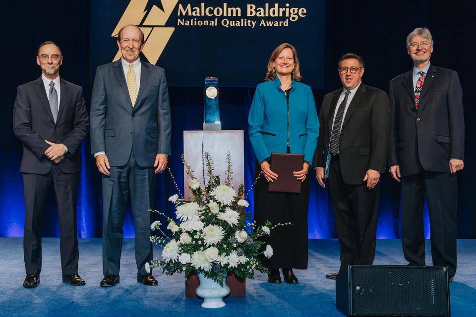 5 people standing on a stage