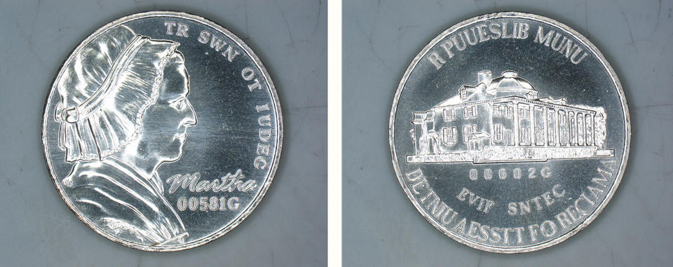 The nickel prototype, which is the same shape and size as a regular nickel, but instead of Thomas Jefferson has a profile of Martha Washington in a mob cap and dummy text instead of "E Pluribus Unum."