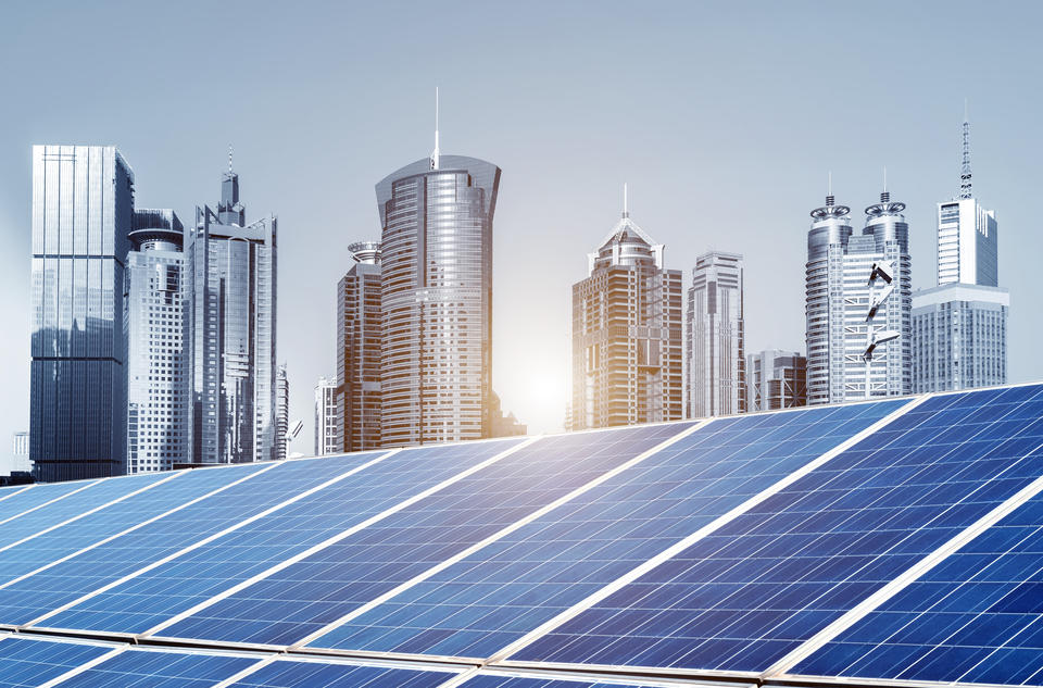 Cityscape in the background. Solar panels in the foreground.