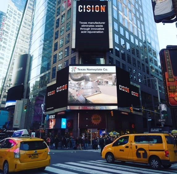 Texas Nameplate Company billboard in New York City. The caption reads "Texas manufacturer eliminates waste through innovative acid rejuvenation."