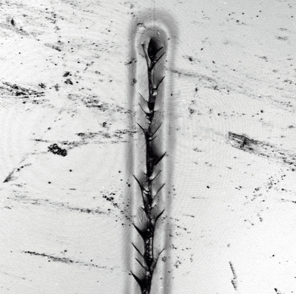 A photomicrograph showing a finger-shaped, nanosized scratch in an auto body coating material.