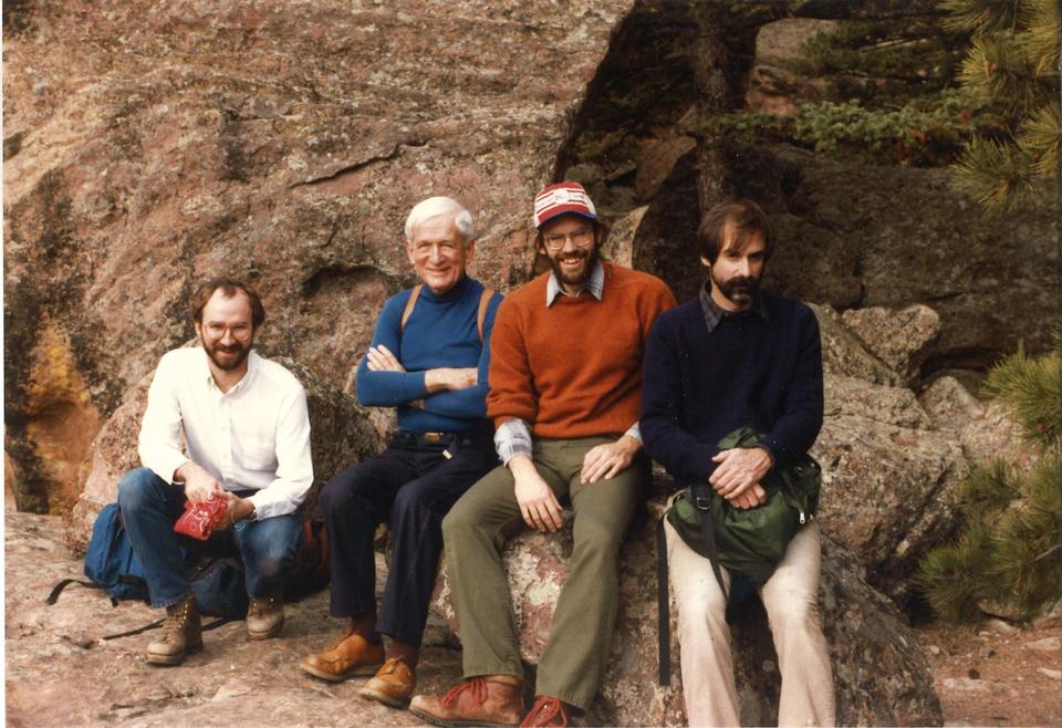 Four men sitting on a rock