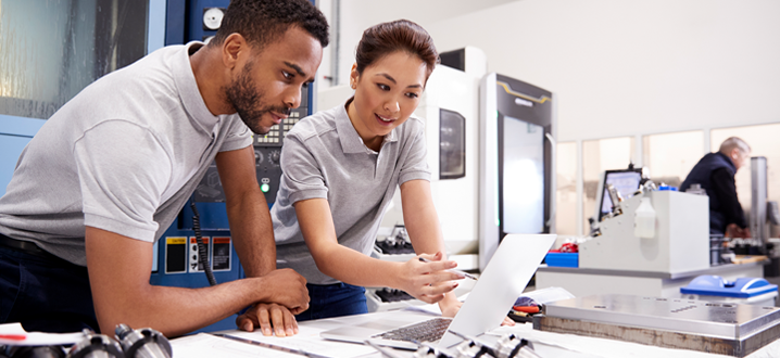 Two Engineers Using CAD Programming Software On Laptop