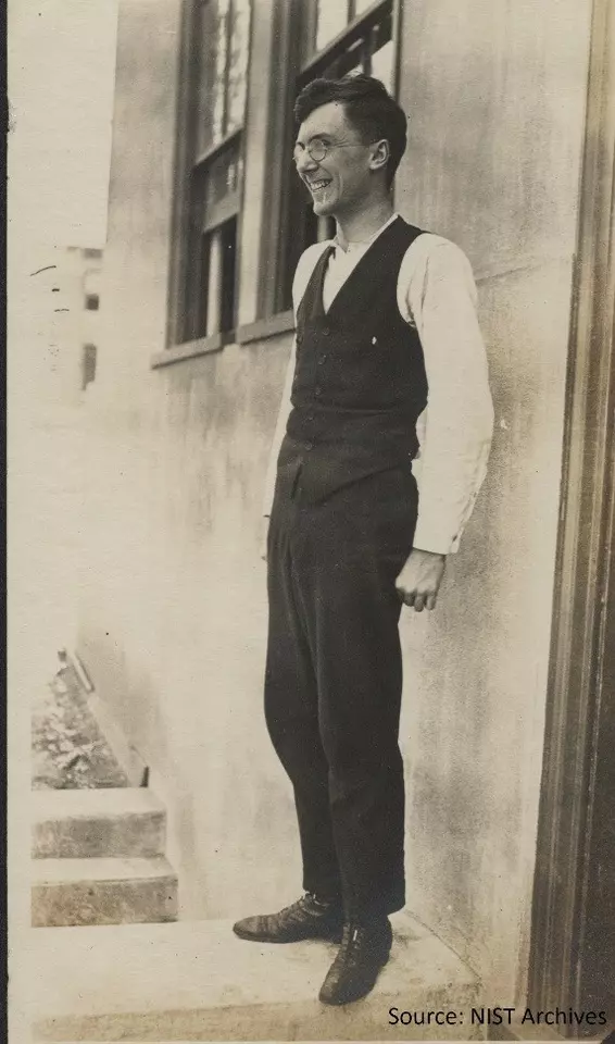 man in a suit standing by a building