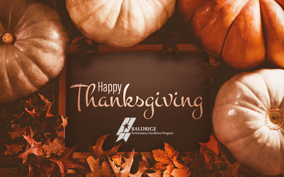Happy Thanksgiving from the Baldrige Program showing a rustic background with pumpkins and autumn leaves.