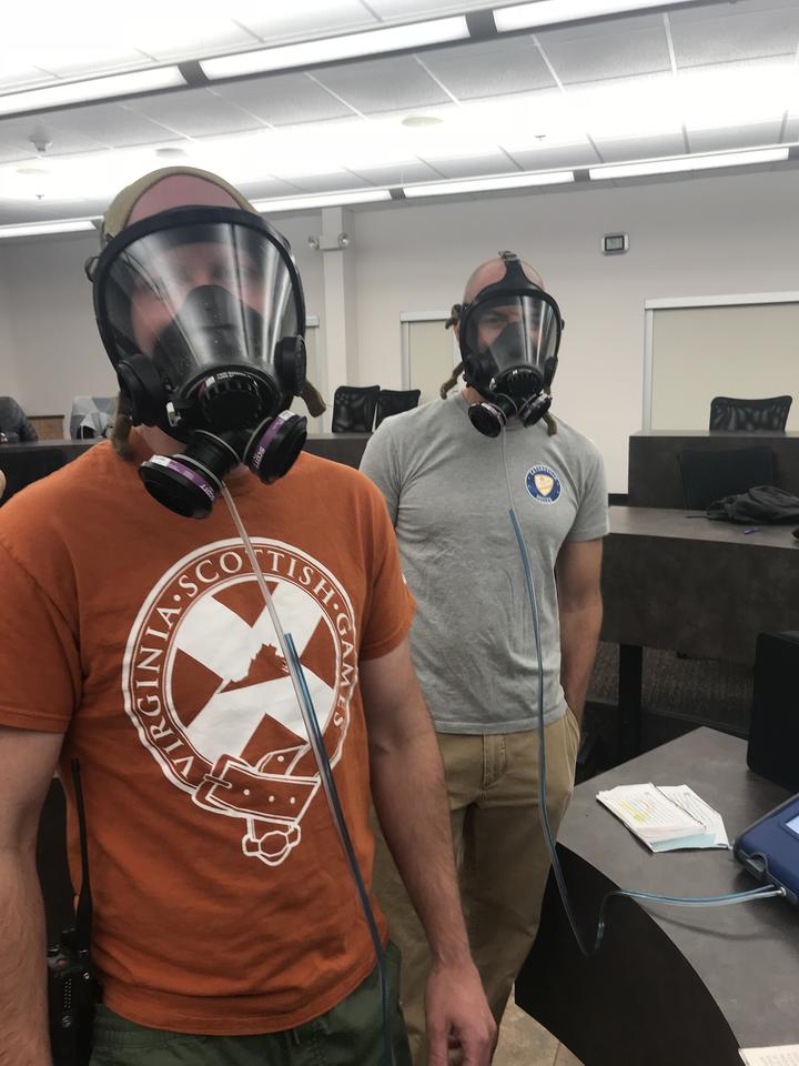 two men wearing SCBA masks hooked up to a respirator