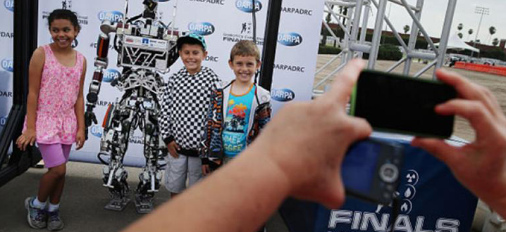 kids posing with a robot for a manufacturing video