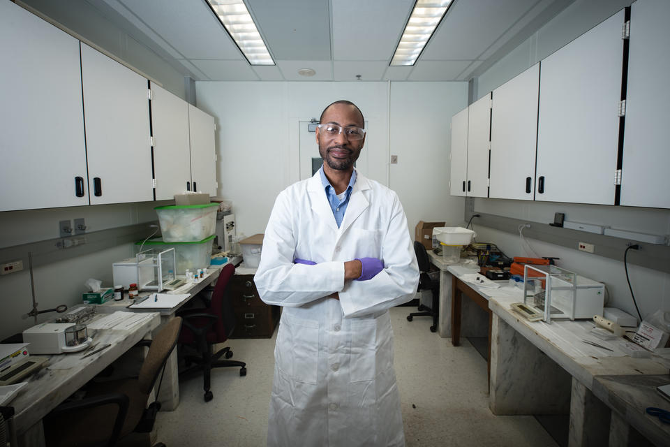 Man in a white lab coat standing in the middle of a lab
