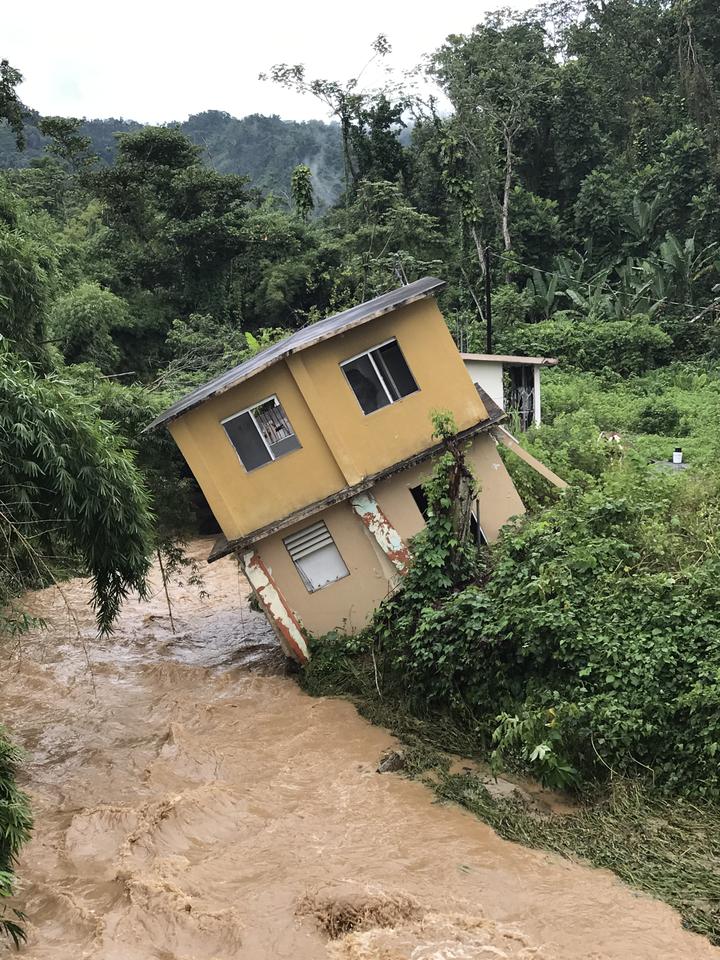 Home tilting into a river in Utuado, Puerto Rico