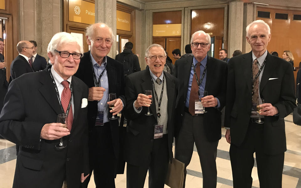 group of five men holding champagne flutes
