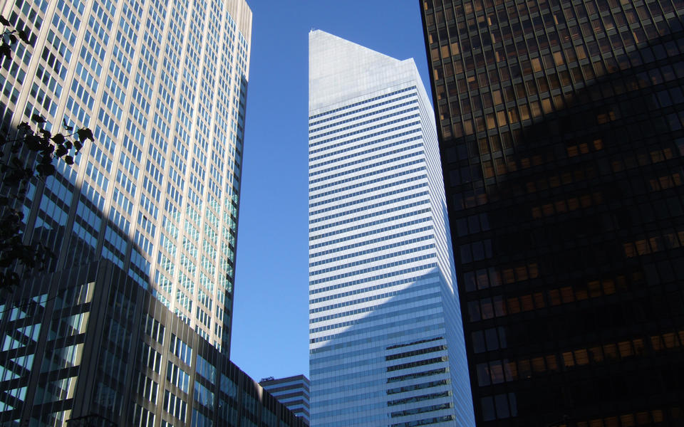 white office building with a wedge top among other skyscrapers