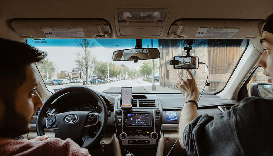 driver and passenger on a city street while interacting with a cellphone