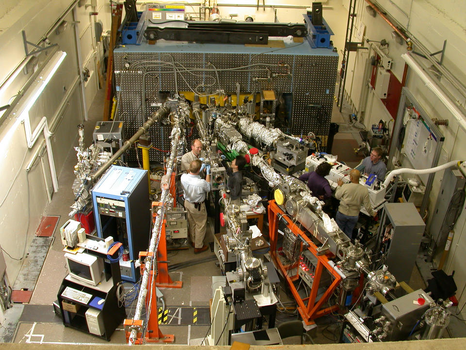 Overhead view of scientists standing among linear devices in a lab