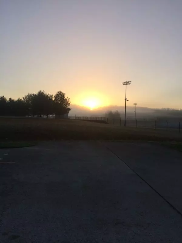 Photo showing sunrise over a high school field (with no people)