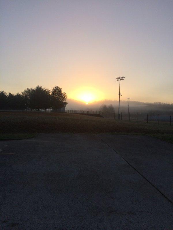 Photo showing sunrise over a high school field (with no people)