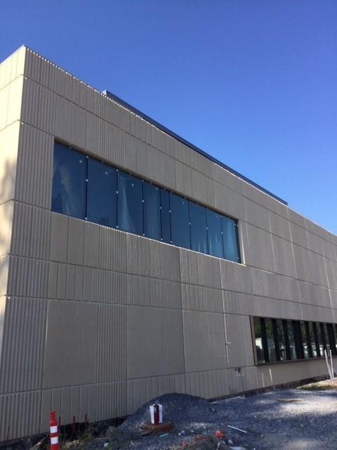 Exterior view of building addition, brown wall with dark windows