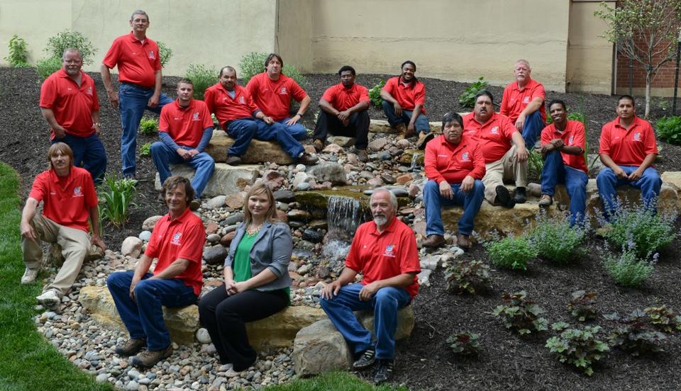 Landscaping workers sitting outside near university gardens