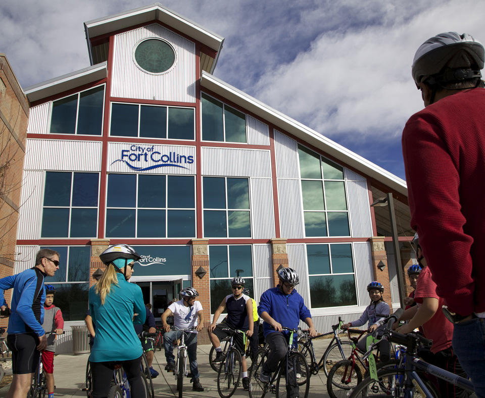 People gaithering in front of building getting ready to ride bicycles in the City of Fort Collins, Colorado.