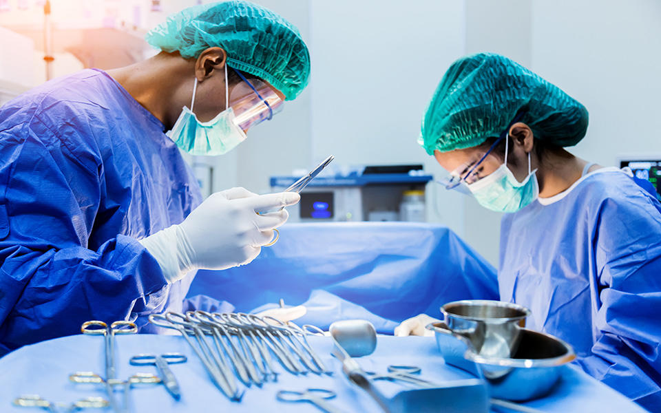 Surgical technologists helping doctor in operation room.