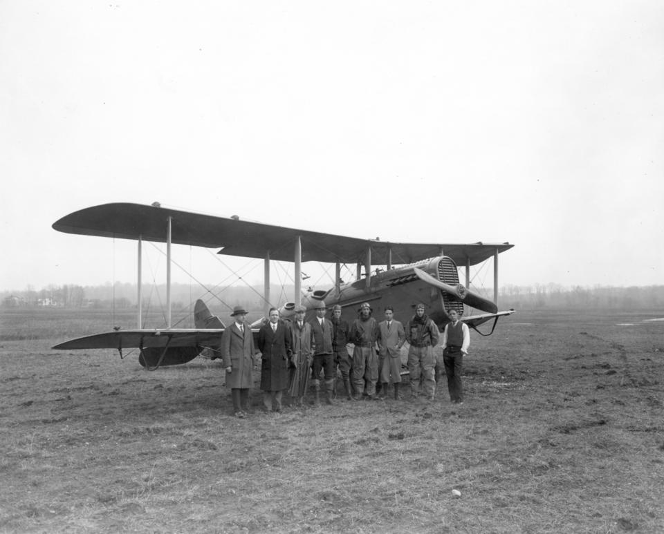 Group of people standing in front of airplane