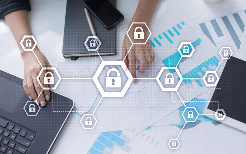 What CAMC Health System has learned from the Baldrige Cybersecurity Excellence Builder. Photo shows woman hands around all her mobile devices sitting on top of paper with graphs and showing cyber locks in front of them connected to each other.