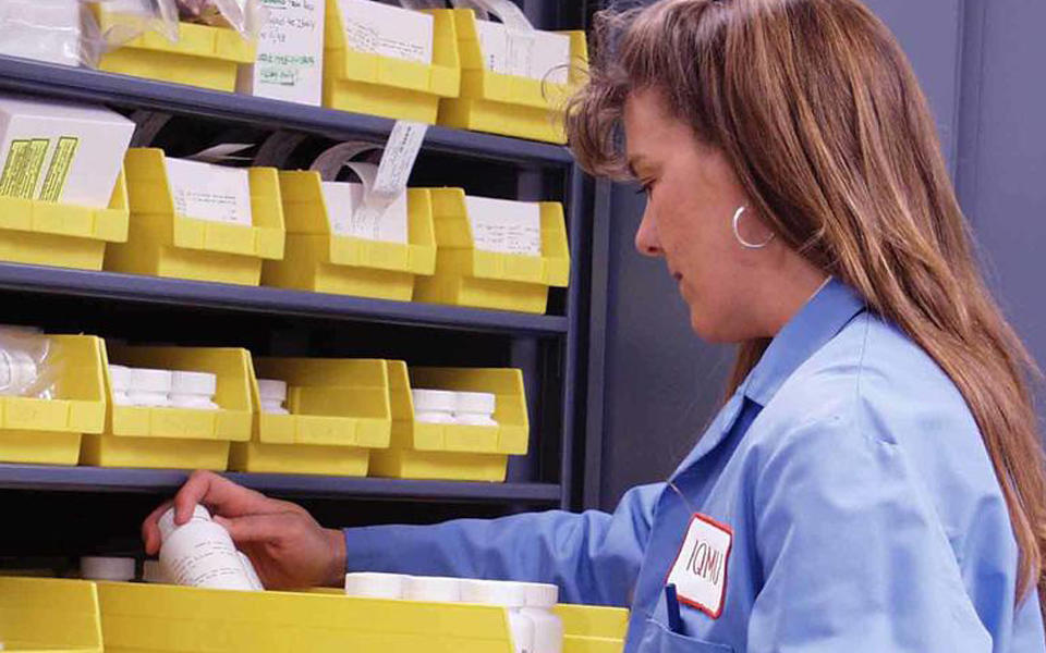 A pharmacist at the Veterans Affairs Cooperative Studies Program Clinical Research Pharmacy Coordinating Center sorting through prescriptions.