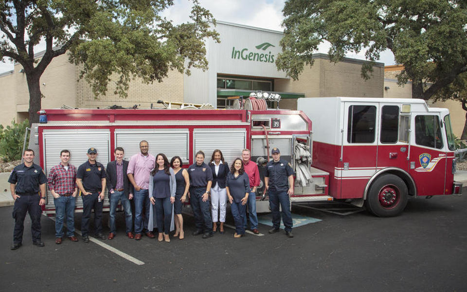 Photo of InGenesis employees in front of fire truck outside.