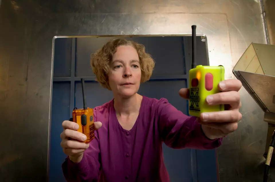 woman holding two communications (radio) devices
