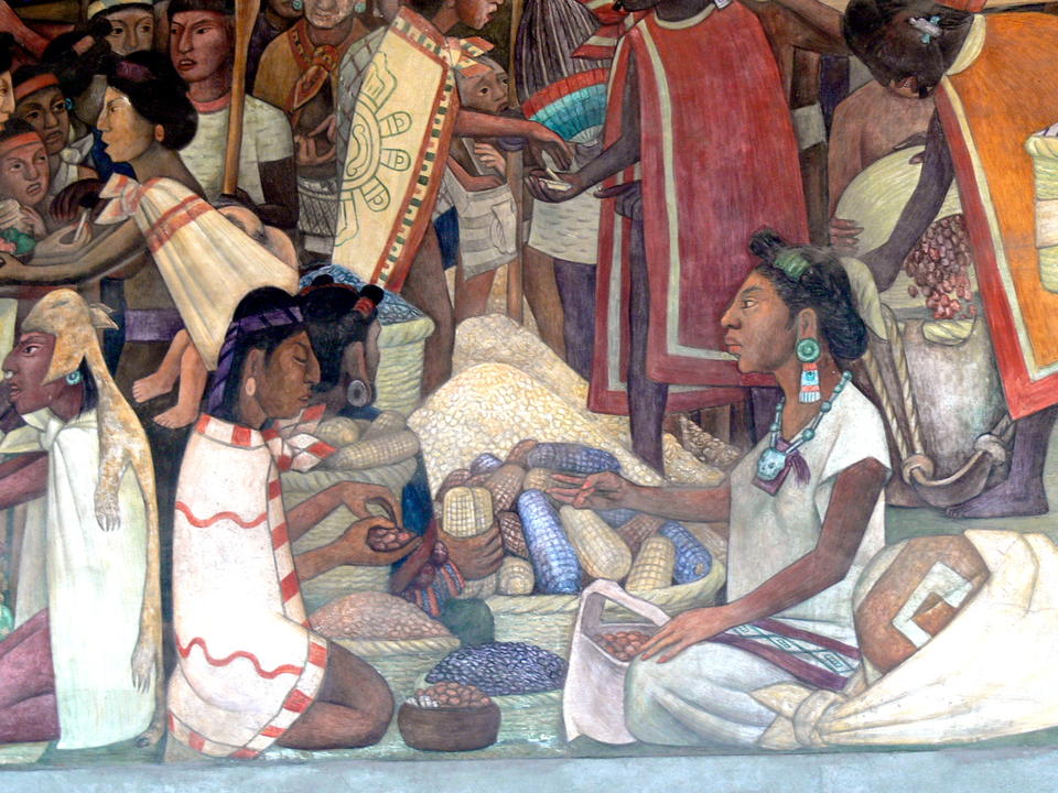 two seated Aztec merchants trading what looks like nuts