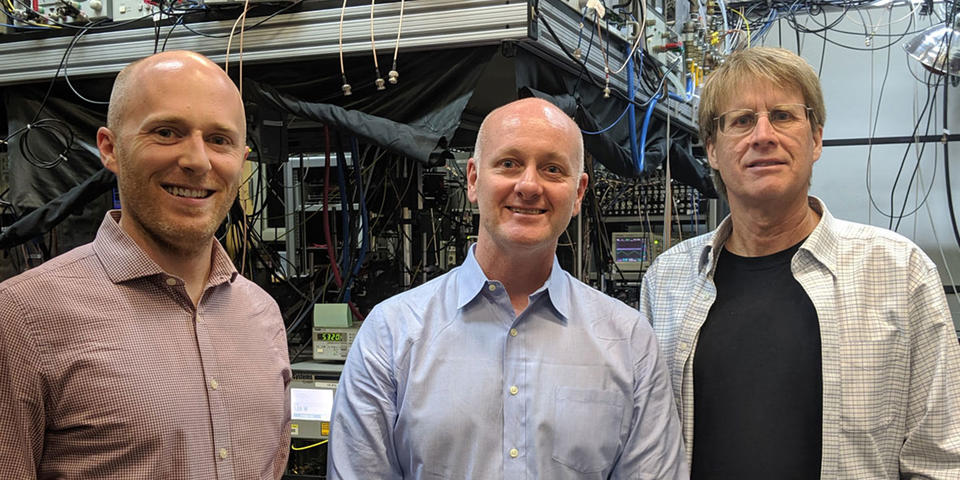 image of Kyle Clark-Sutton (RTI), Alan O’Connor (RTI), and Dr. Chris Oates (NIST Boulder Group Leader, Optical Frequency Measurements Group)