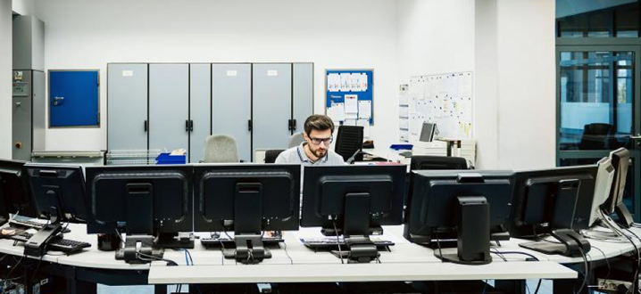 man sitting at computers in a cybersecurity center