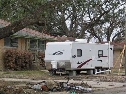 mobile trailer parked on the front lawn of a house damaged by Hurricane Katrina